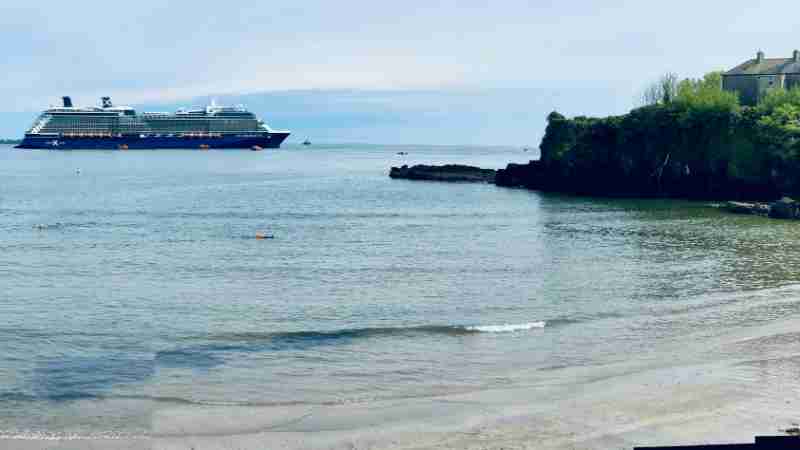 A luxury cruise ship near the scenic coast of Dunmore East, Ireland, with serene waters and a picturesque cliffside., tags: een heropleving van het - pexel