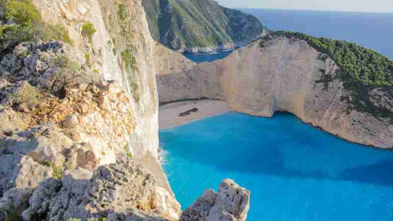 Stunning cliffside view of Navagio Beach's turquoise waters and sandy cove in Zakynthos, Greece. - Stunning cliffside view of Navagio Beach's turquoise waters and sandy cove in Zakynthos, Greece., tags: en - pexel